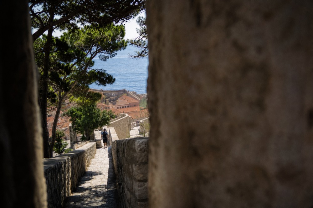 Stone staircase climbing the city walls with terracotta rooftops below