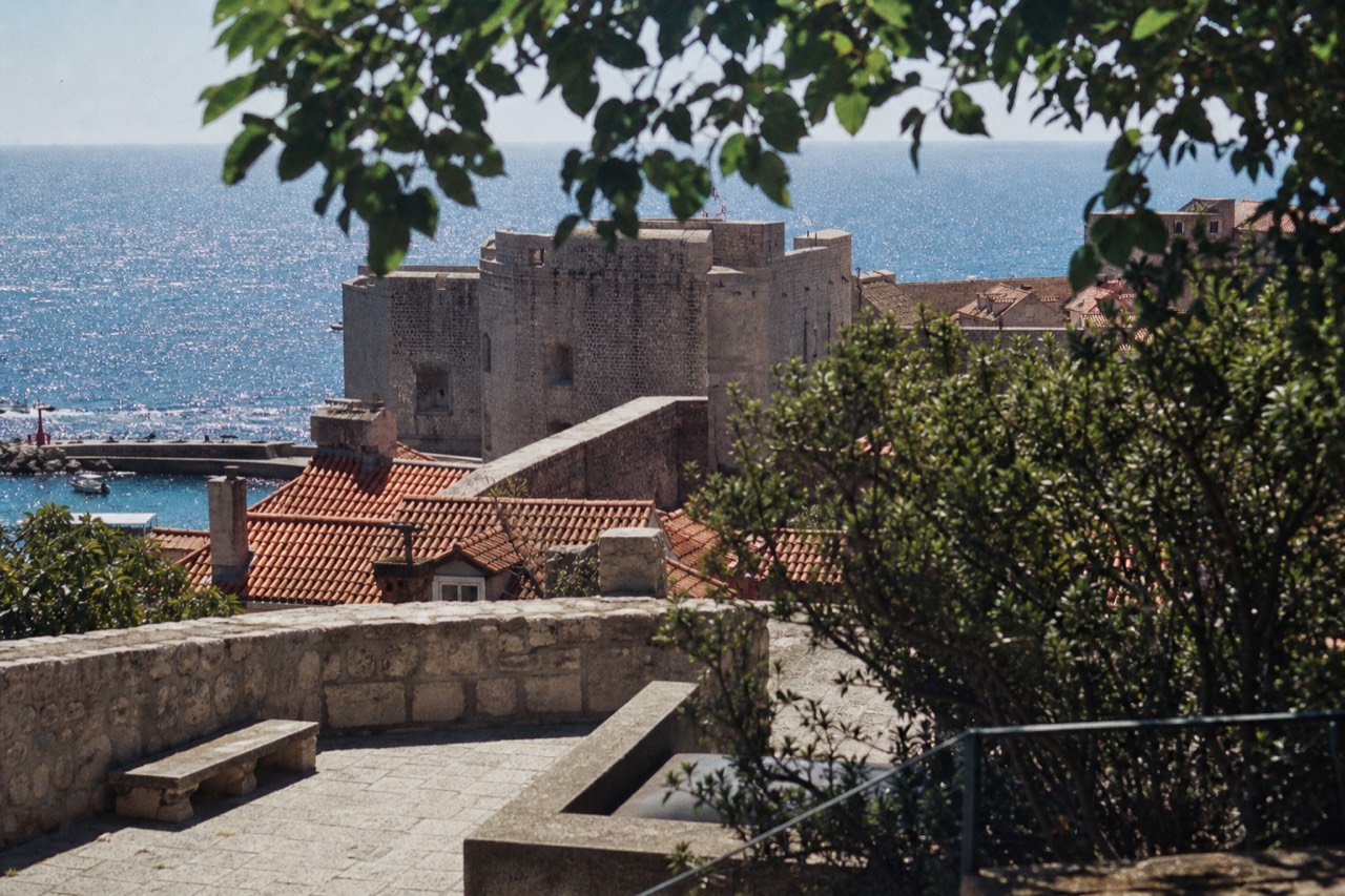 Stone city walls rising above red rooftops and the Adriatic sea