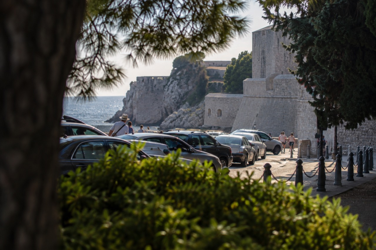 A taxi rank beside the stone walls of Dubrovnik outside Pile Gate in late afternoon light