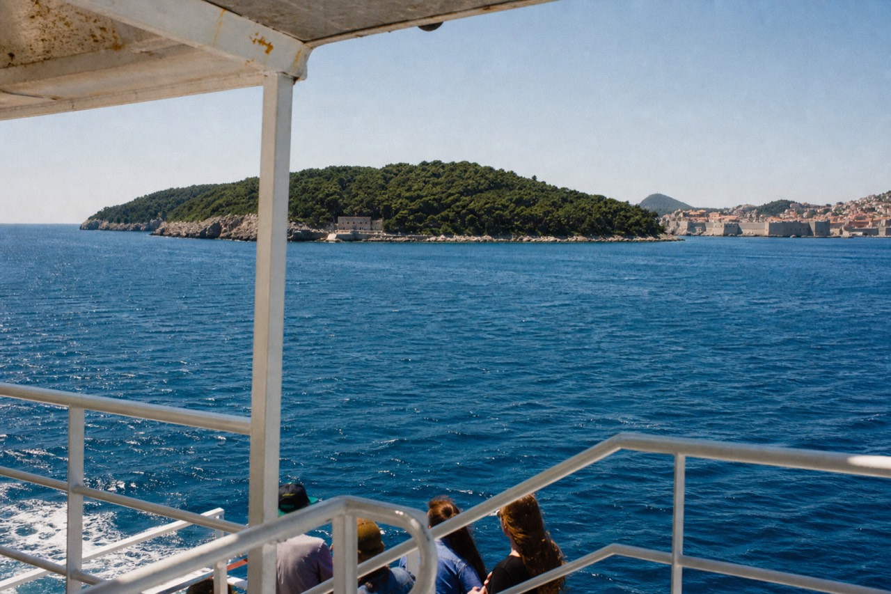 A view of Lokrum island from the ferry, with the Old Town in the distance