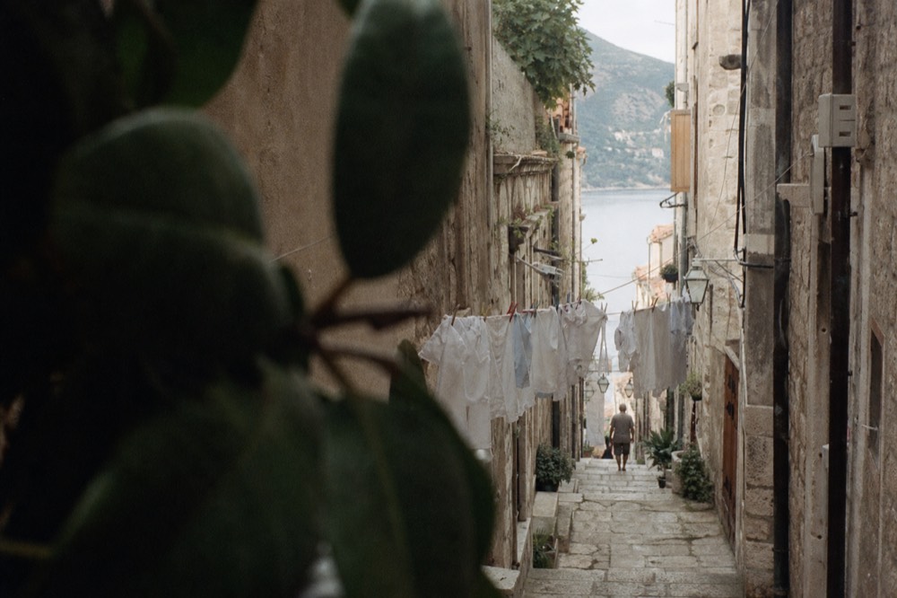 Narrow side street in Dubrovnik with laundry lines and worn stone steps