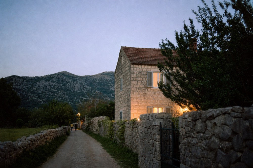A quiet country lane between stone walls and green fields in the Konavle valley