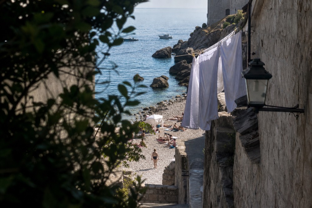 A quiet stone lane in Dubrovnik Old Town with laundry hanging above