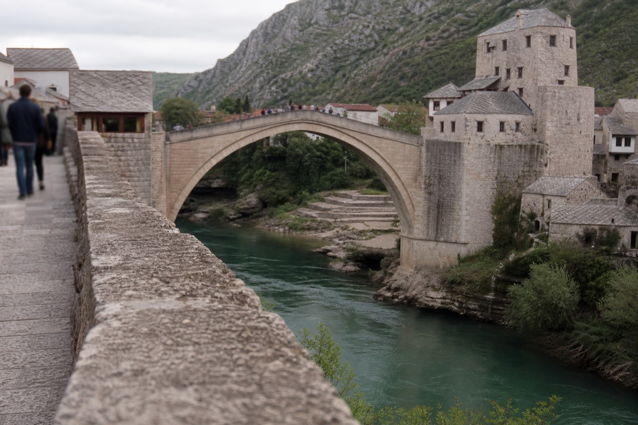 The stone arch of the old bridge in Mostar above the green Neretva river