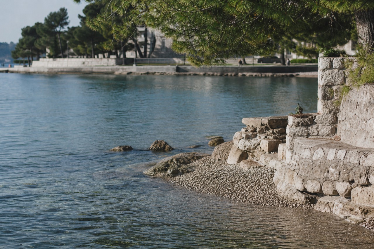 Pine trees and a stone promenade along the Lapad bay in Dubrovnik