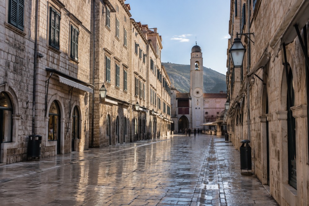 The limestone Stradun street in Dubrovnik Old Town in soft morning light with shutters closed and the street empty