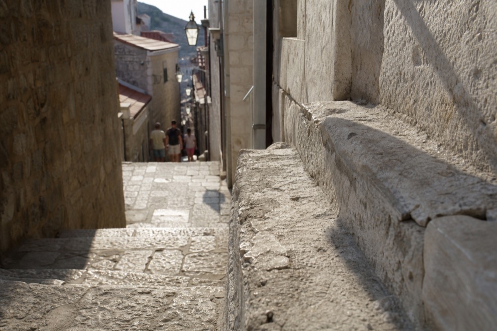 Narrow limestone lane in Dubrovnik Old Town with worn stone steps