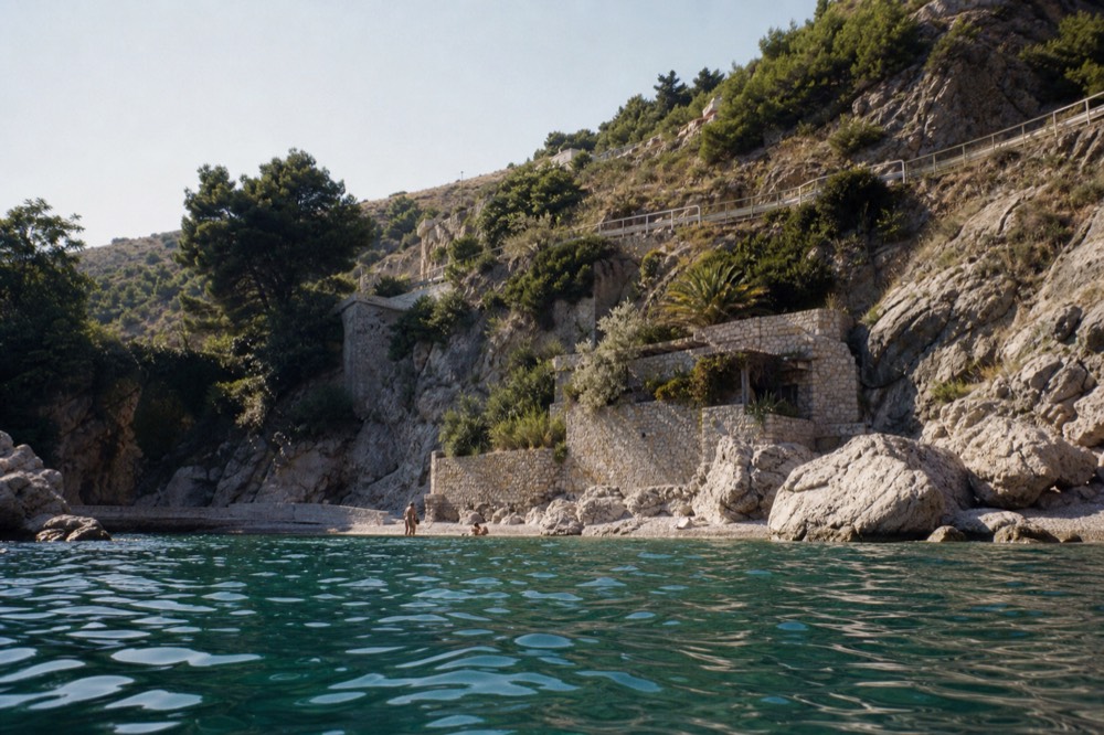 A coastal road winding along steep hills above a blue bay