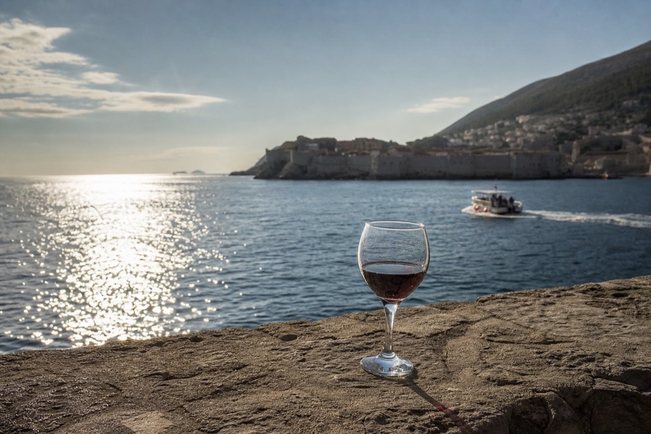 A glass of red wine on a stone terrace above the Adriatic sea near Dubrovnik