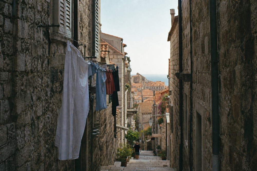Narrow side street in Dubrovnik Old Town with stone steps and hanging laundry