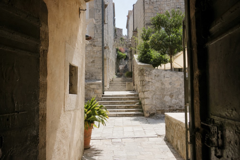 A quiet stone street in Dubrovnik Old Town with a staircase leading up to a residential area