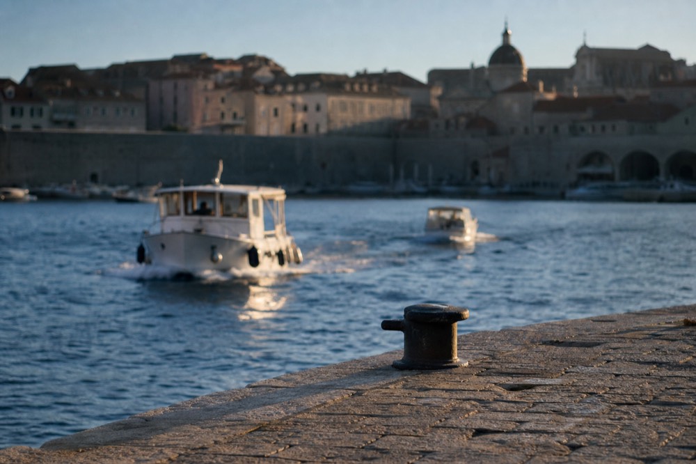 Autumn morning on the Ploče waterfront with calm sea and the Old Town walls in soft light
