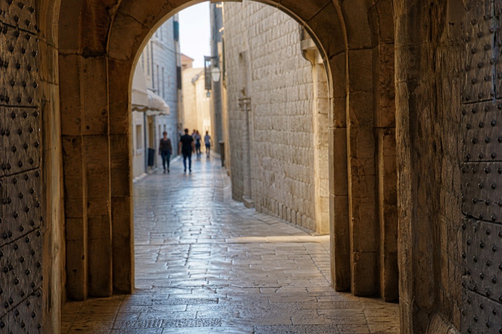 Ploče Gate stone archway with the Old Town street visible beyond and morning light on the pavement