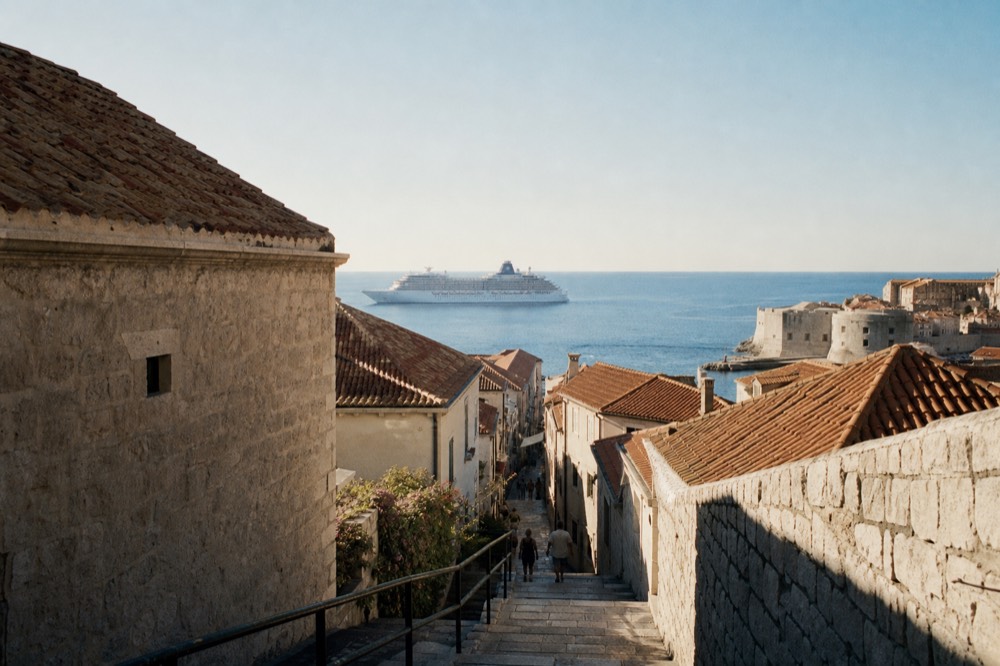 A cruise ship anchored offshore from Dubrovnik Old Town in morning light