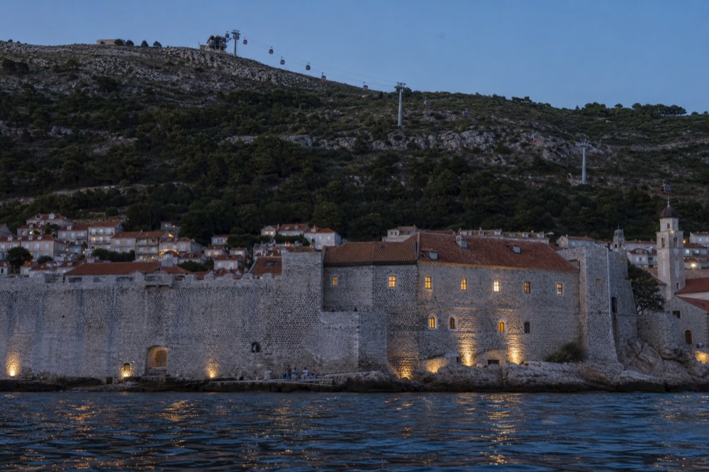 The Dubrovnik cable car cabins travelling up the hillside above the red rooftops of the Old Town