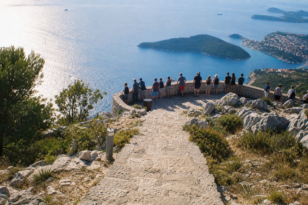 Stone viewing terrace on Mount Srd with visitors looking out over the sea and islands