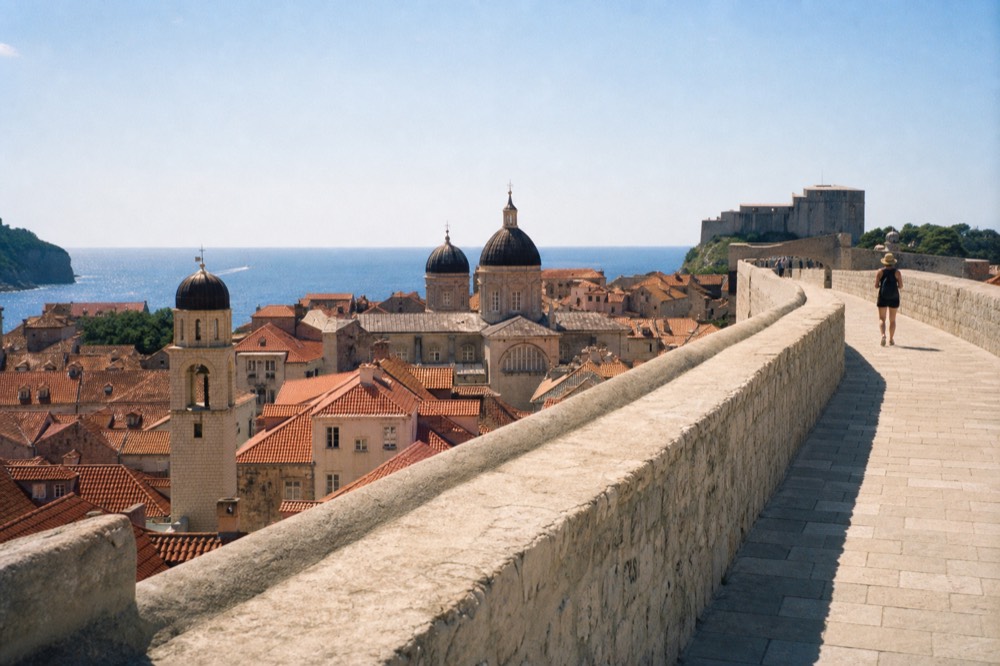 View along the city walls with terracotta rooftops and church towers below