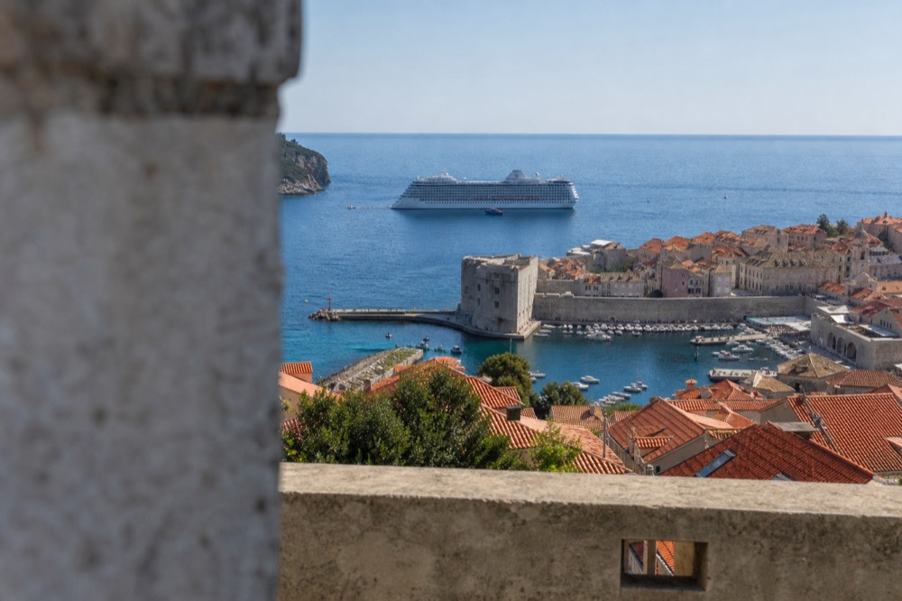 A large cruise ship anchored offshore beyond the Old Town walls
