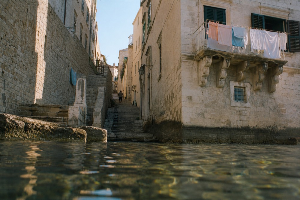 Warm light in an empty side street of Dubrovnik Old Town with laundry on a balcony