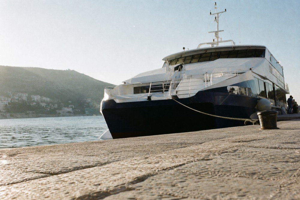 A fast passenger catamaran moored at a seaside port in the morning