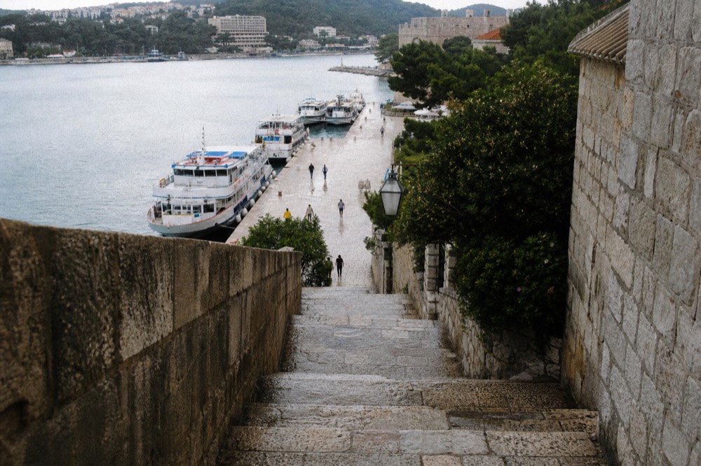 A ferry terminal with passenger boats at anchor along a seaside promenade