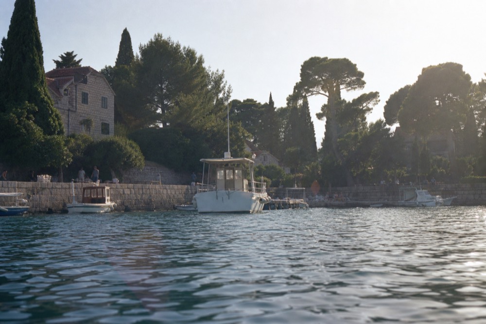 An island harbour at golden hour with fishing boats and a stone promenade