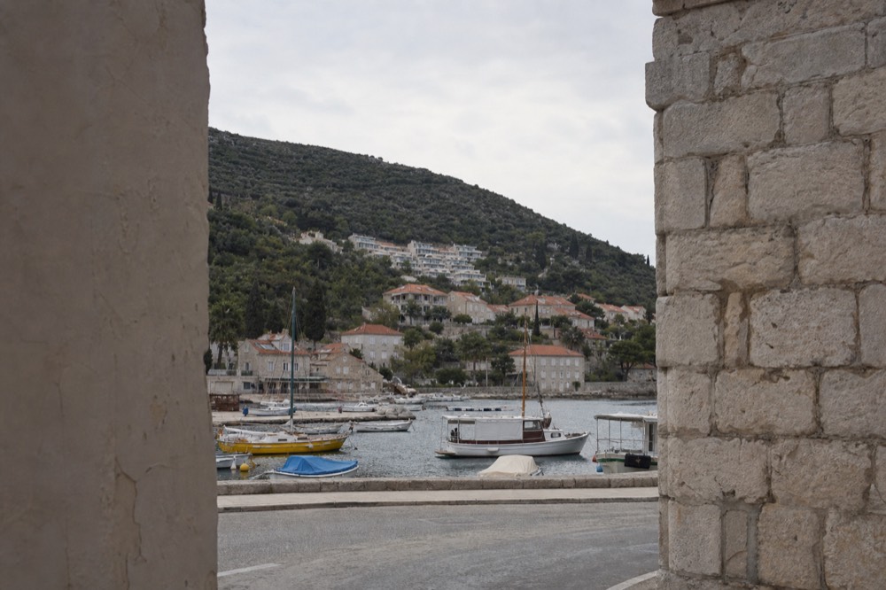 Boats moored in a small harbour beneath steep hills