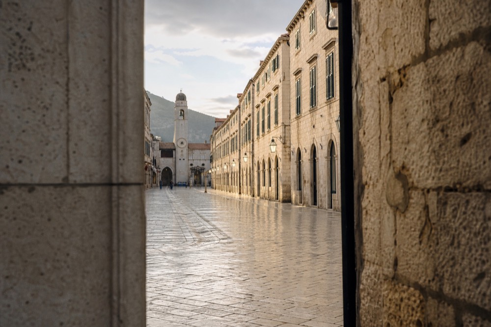 An empty Stradun street in Dubrovnik in winter light with wet limestone paving gleaming