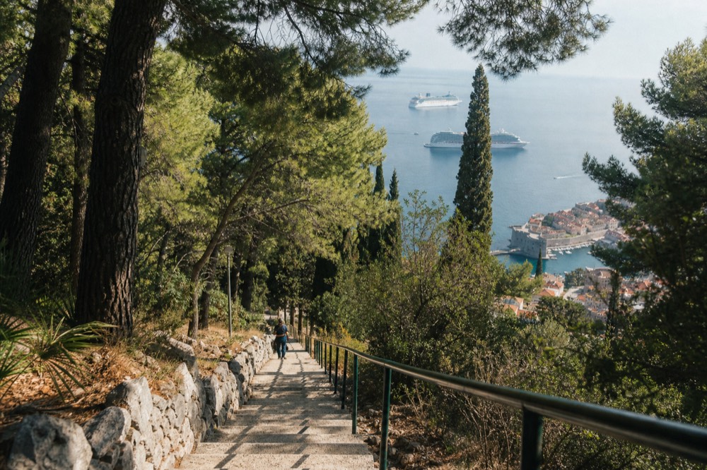 Two cruise ships anchored offshore from Dubrovnik old town seen from a hillside