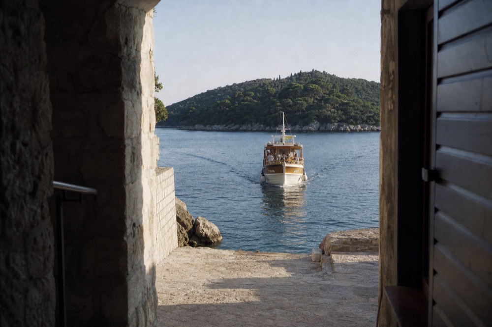 A wooden boat approaching a green island in the Elaphiti archipelago