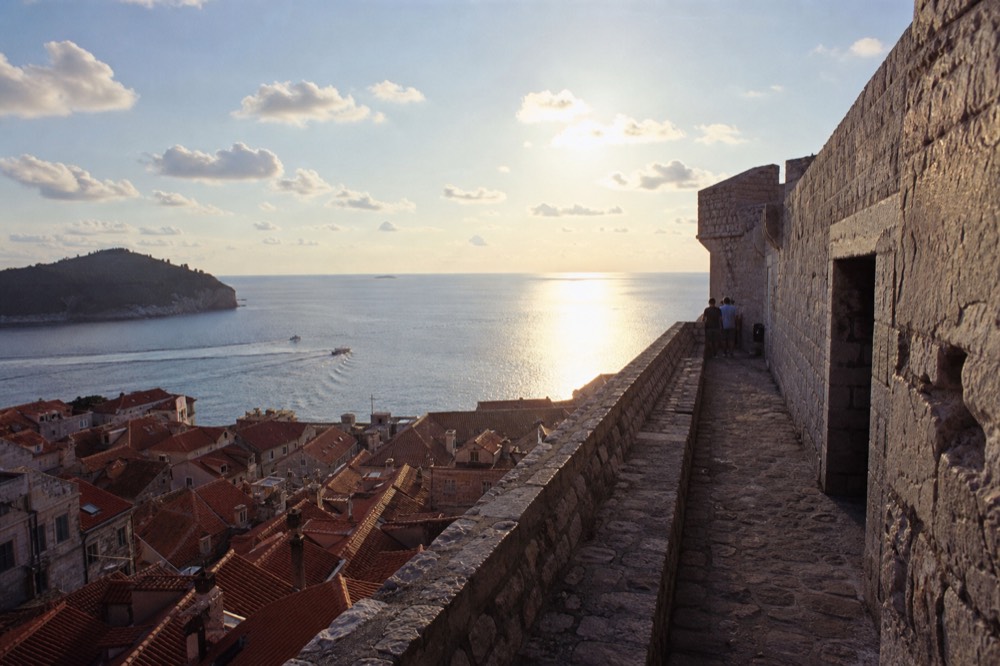 Terracotta rooftops of a walled town seen from a high fortress terrace