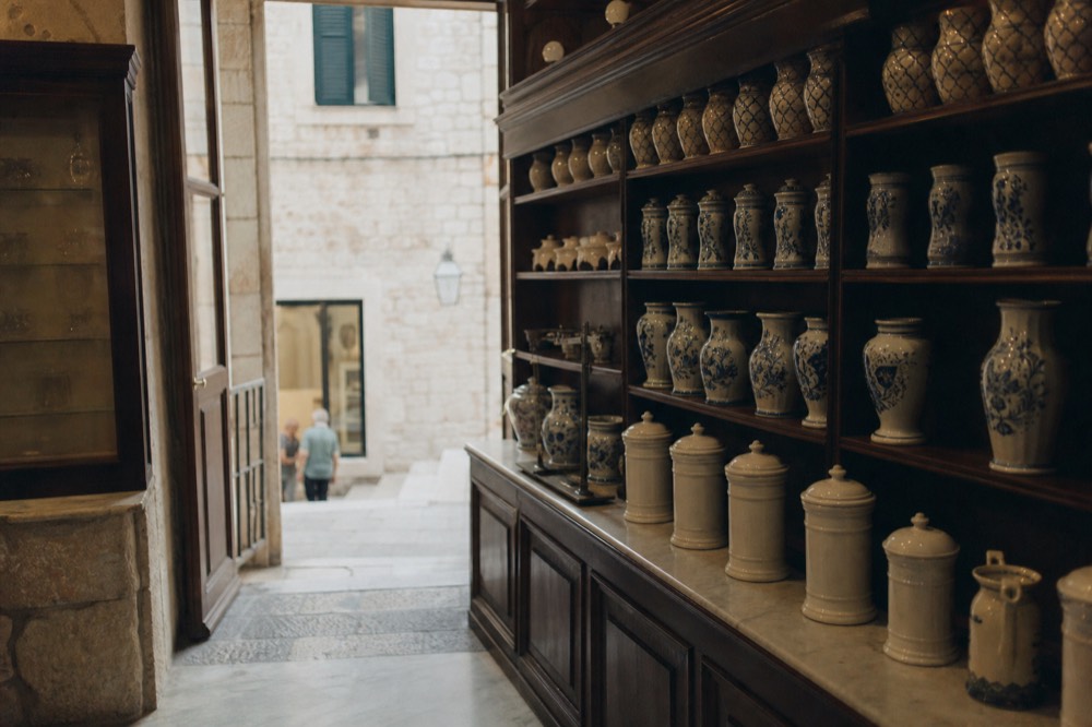 Interior of an old pharmacy with wooden shelves and ceramic jars