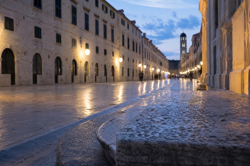 Wide limestone street in an old town at morning with baroque buildings on both sides
