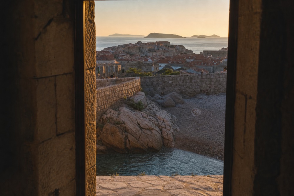 Golden sunset over Dubrovnik Old Town rooftops and the island-studded Adriatic horizon