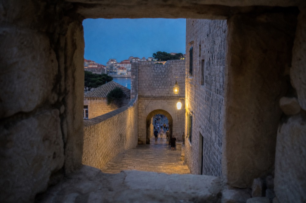 Evening light on a stone gate and paved lane in the old city