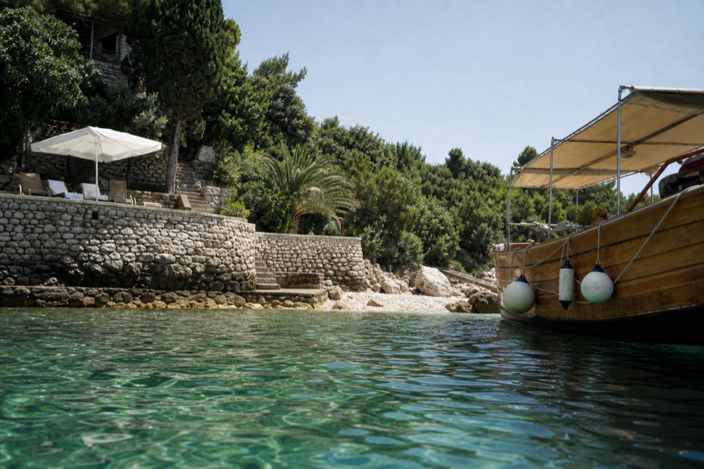 Wooden boat anchored in a quiet Adriatic bay near green islands