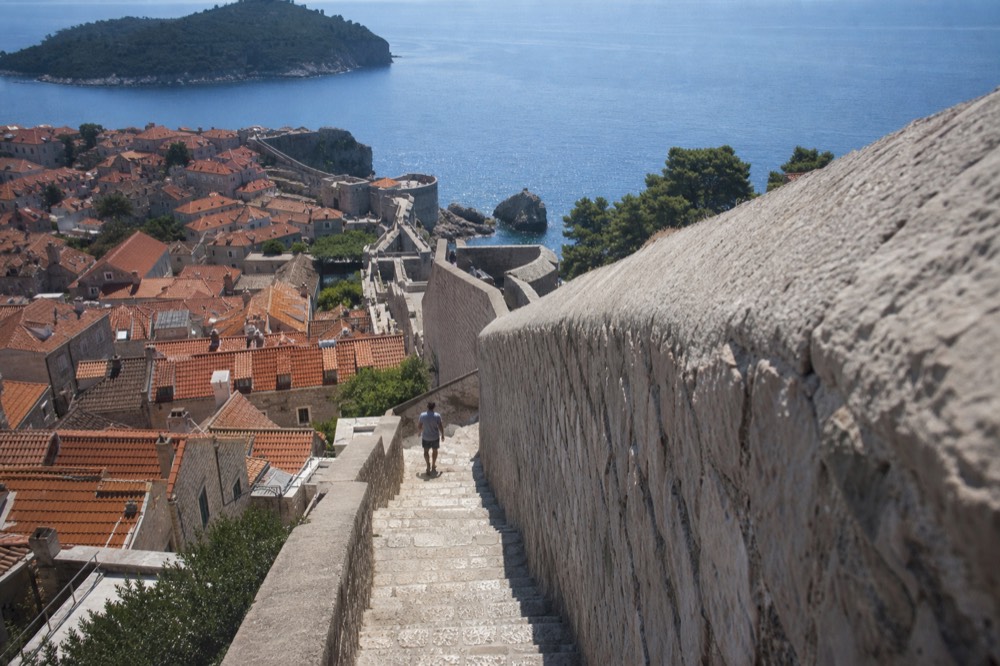 View along the Dubrovnik city walls with terracotta rooftops and the Adriatic