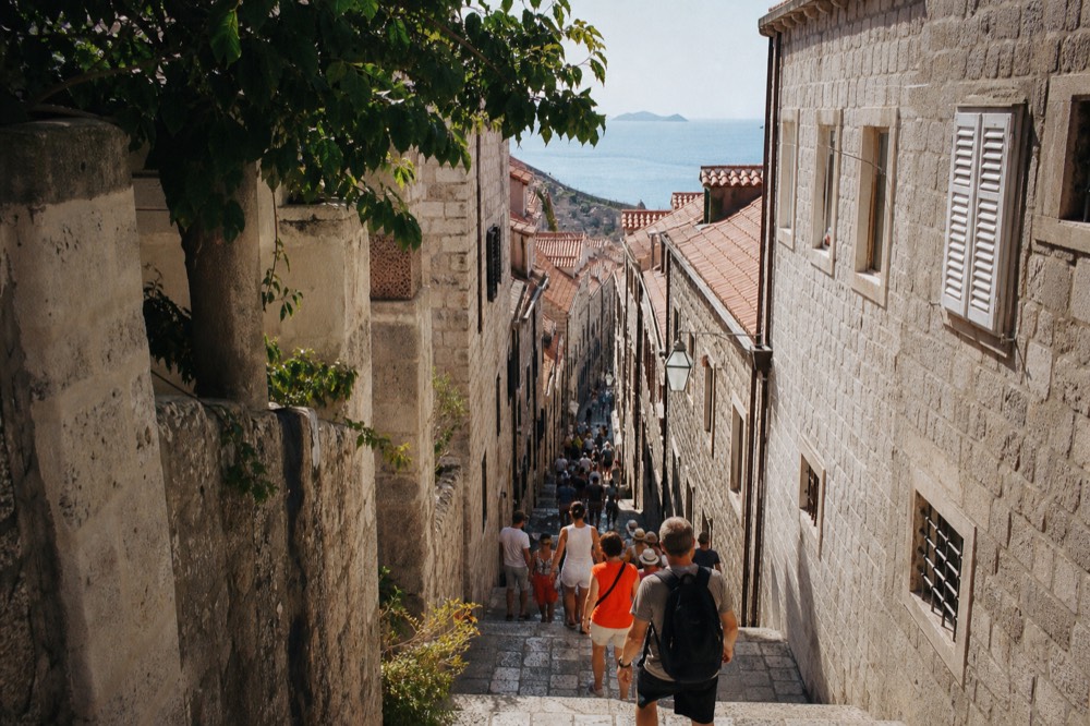 Crowded limestone street in Dubrovnik old town under midday sun