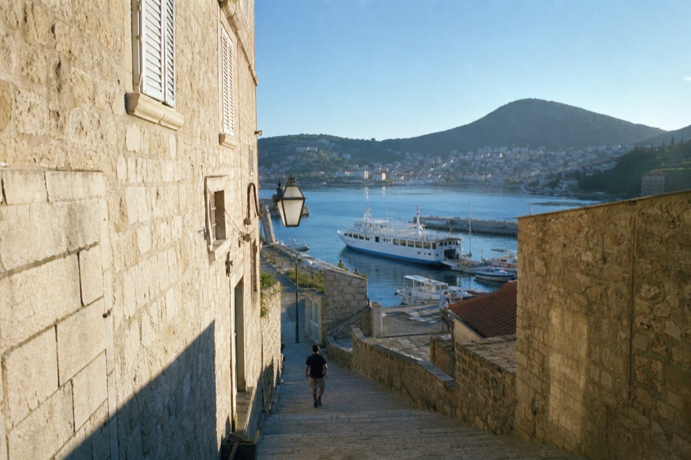 A ferry and small boats moored in a harbour with hills behind