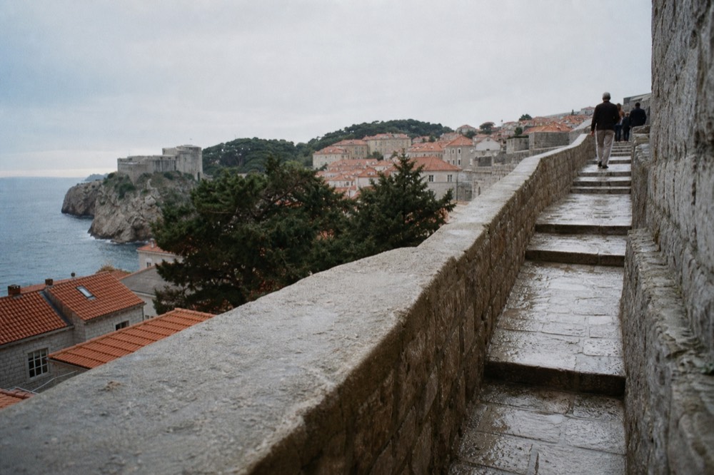 Stone stairway climbing onto the city walls ramparts above red rooftops