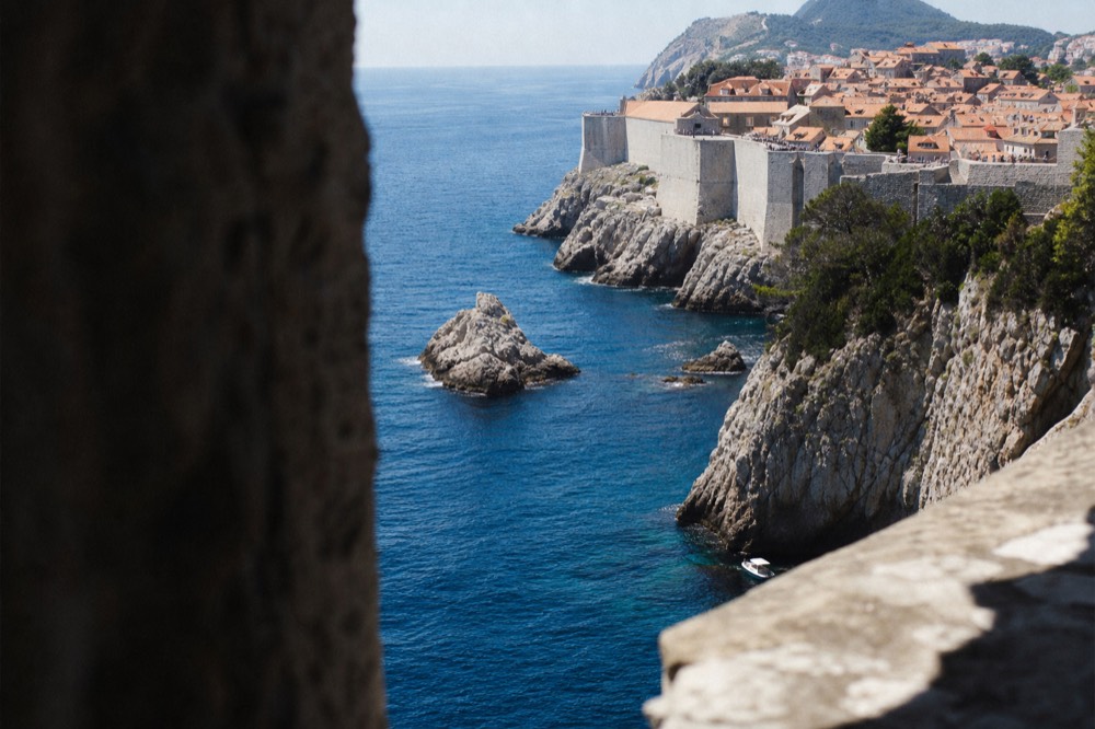 Blue Adriatic water and a rocky coastline below the walls of Dubrovnik