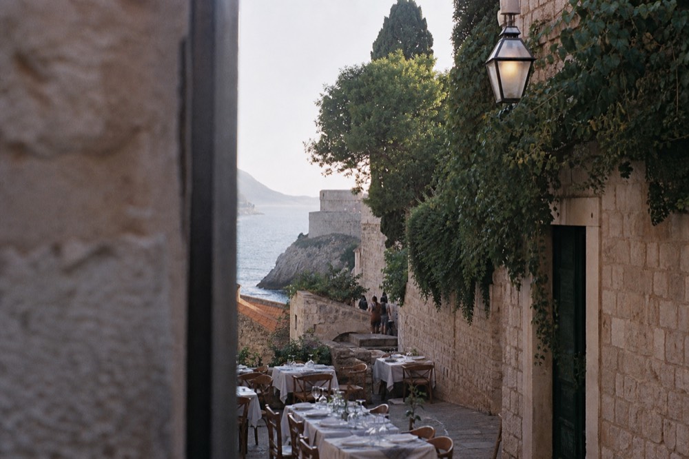 Tables set for dinner on a narrow stone street inside the walled old town