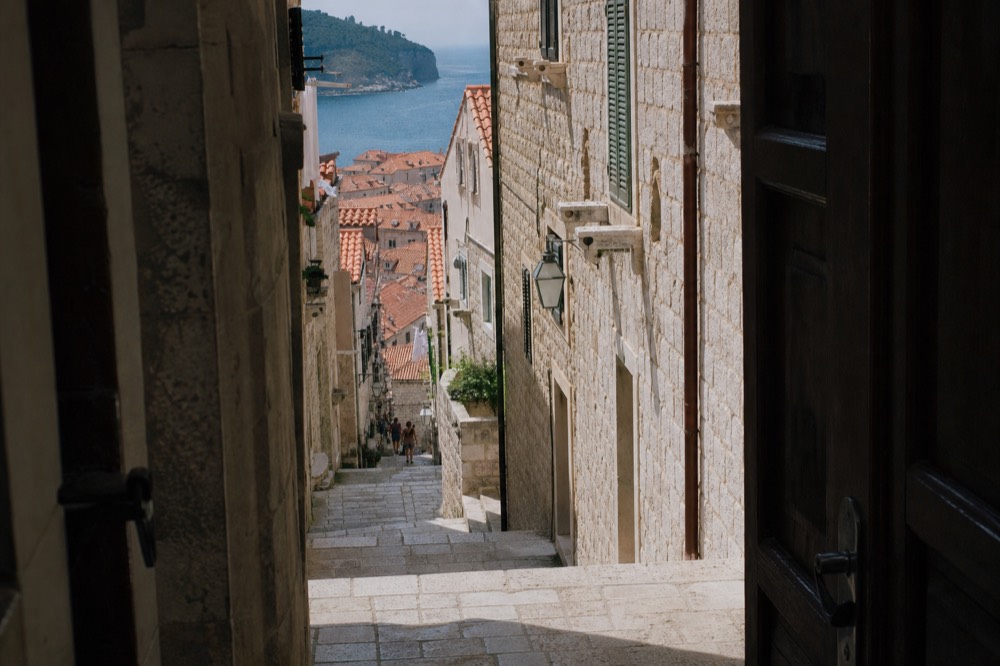 A narrow stone staircase street in Dubrovnik Old Town in early morning light