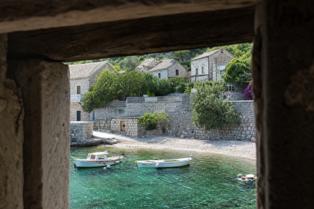 A quiet island village waterfront with stone houses and moored small boats