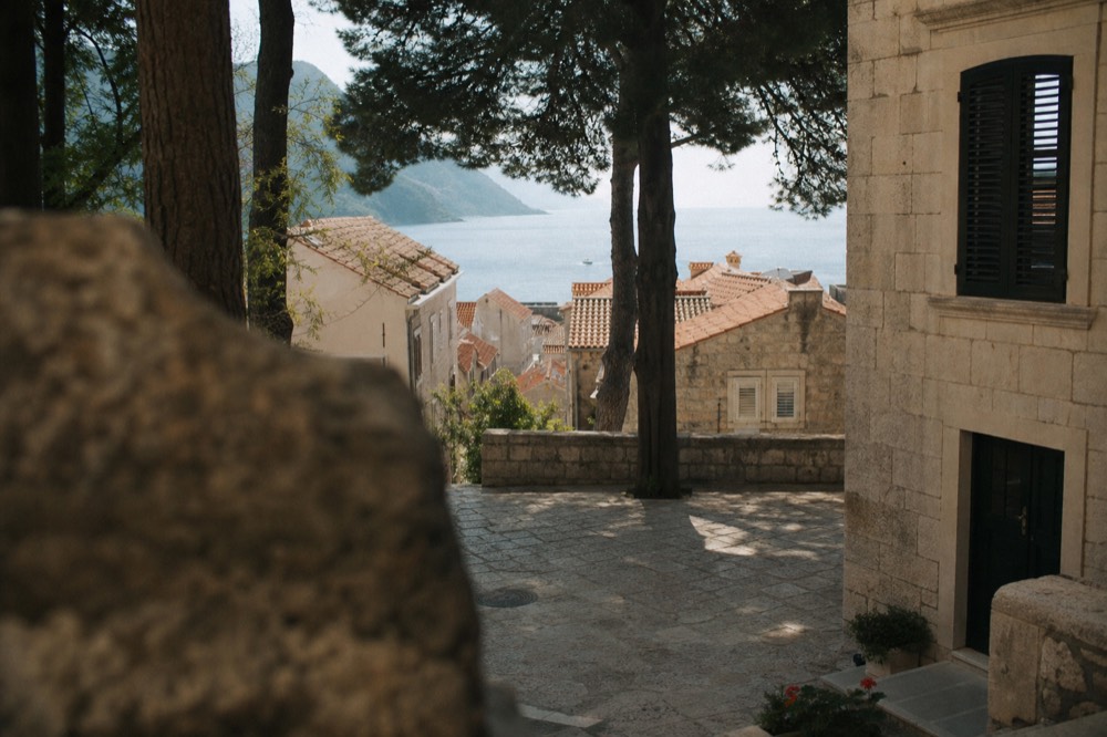 A quiet stone square with worn steps and old shutters in Dubrovnik