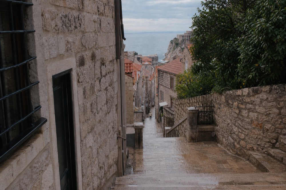 A narrow stepped lane in Dubrovnik Old Town between stone houses