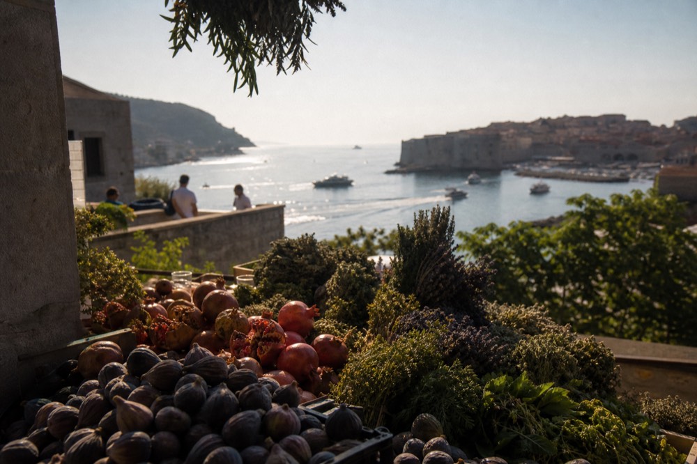 A morning market stall piled with figs, pomegranates and bunches of herbs